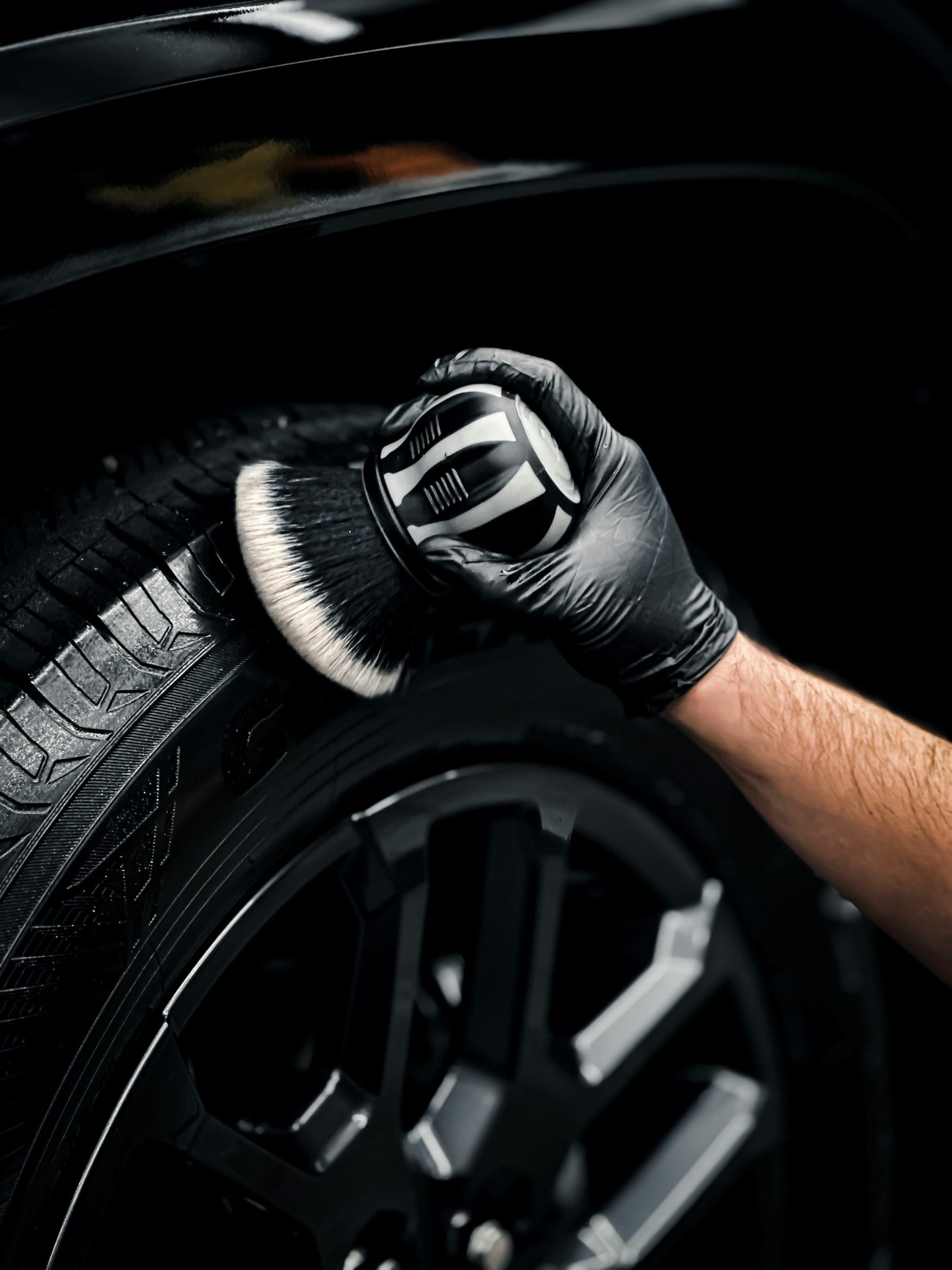 Detailer using a brush on a tire and wheel